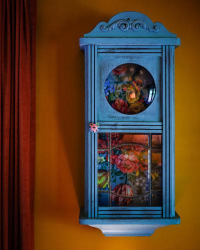 a blue cabinet with a painting of flowers on it at Boshuisje Pinus Sonnevijver Residences in Lanaken