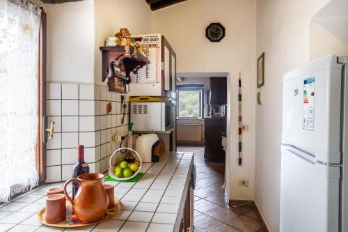 a kitchen with a white tiled floor and a refrigerator at Querciagrossa da Dora in Roccastrada