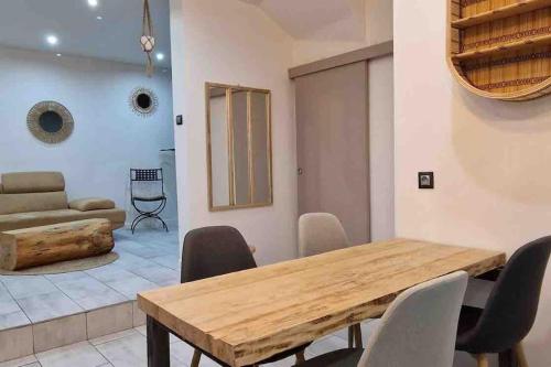 uma sala de jantar com mesa e cadeiras de madeira em Les Suites du Palais em Carcassonne