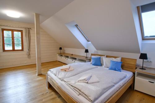 a bedroom with a large bed with blue pillows at Chalupa Pod Šerovnou in Prachatice
