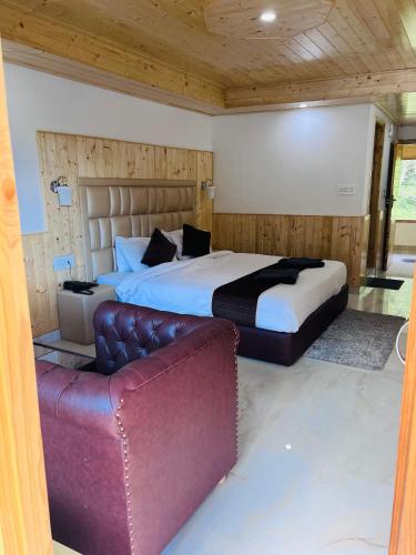 1 dormitorio con 1 cama grande y 1 sofá en Aadarsh Hotel, Nanital, en Nainital