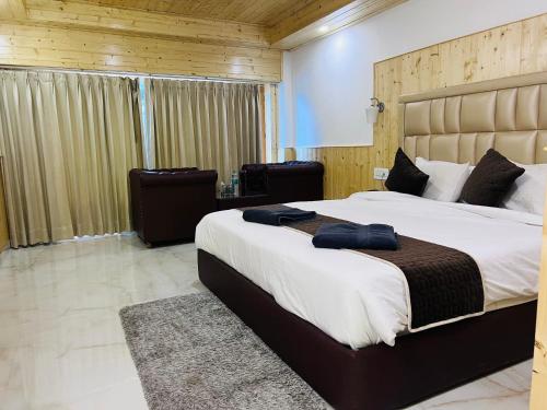 1 dormitorio con 1 cama grande y 2 toallas. en Aadarsh Hotel, Nanital, en Nainital