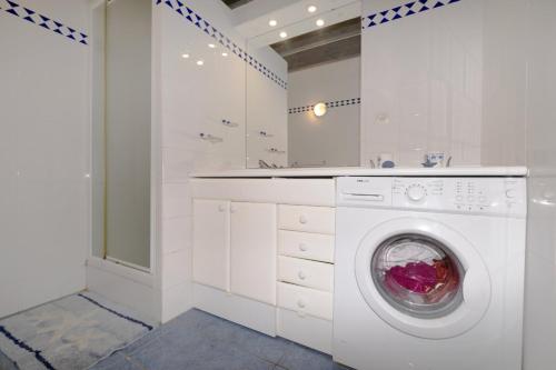 a white laundry room with a washing machine at Arcachon pied in Arcachon
