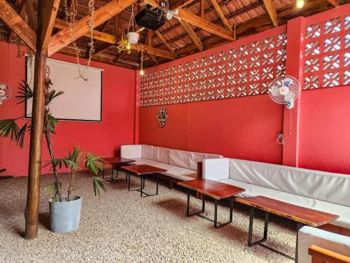 a waiting room with red walls and benches at La Casa Moz in Maputo