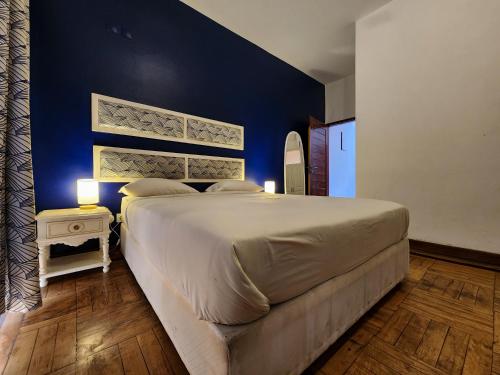 a bedroom with a large bed with a blue wall at La Casa Moz in Maputo