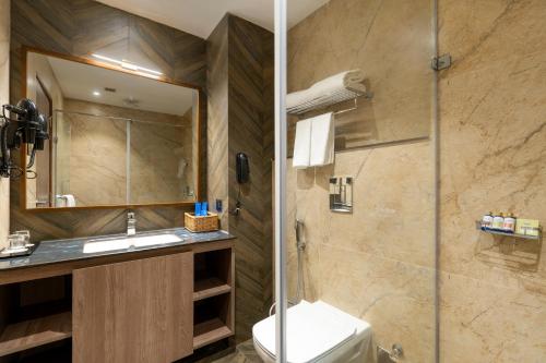 a bathroom with a toilet and a sink and a shower at Cygnett Inn Imperial Tezpur in Tezpur