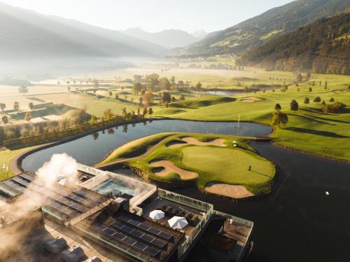 an aerial view of a golf course with a lake at Sportresidenz Zillertal - 4 Sterne Superior in Uderns