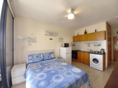 a small bedroom with a bed and a kitchen at Montehugh in Larnaca