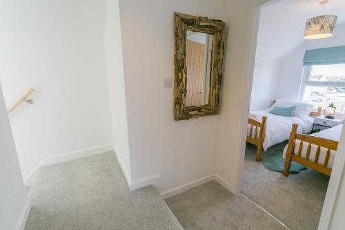 a room with a mirror on the wall and a bed at Y Bwthyn in Rhosneigr