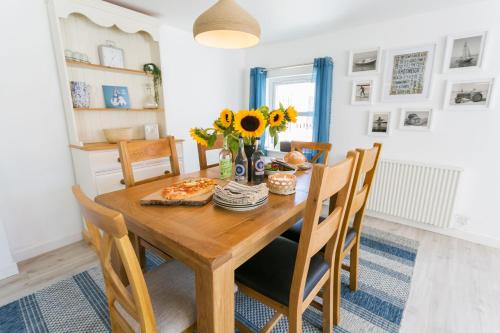 a dining room with a wooden table and chairs at Y Bwthyn in Rhosneigr