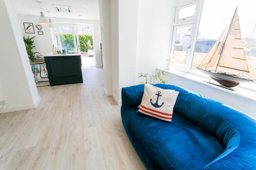 a blue couch with a pillow on it in a living room at Y Bwthyn in Rhosneigr