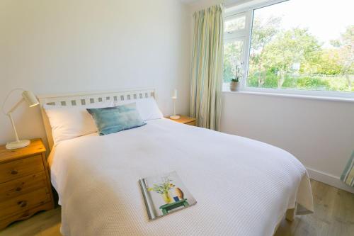 1 dormitorio con cama blanca y ventana en Ynys Las, en Valley
