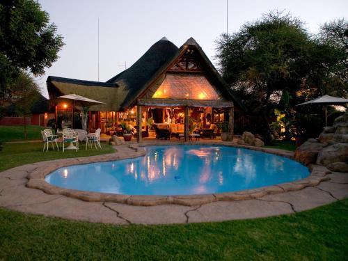 - une piscine en face d'une maison dans l'établissement Ditholo Game Lodge Bela Bela, à Bela-Bela