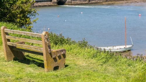 a bench sitting on a hill next to a body of water at Ynys Las in Valley