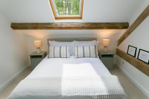 1 dormitorio con 1 cama blanca y 2 mesitas de noche en Ysgubor Wennol en Llanfairpwllgwyngyll