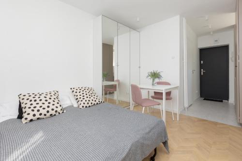 1 dormitorio con 1 cama y 1 mesa con sillas en Modern & Cozy Apartment Warsaw Downtown by Renters en Varsovia