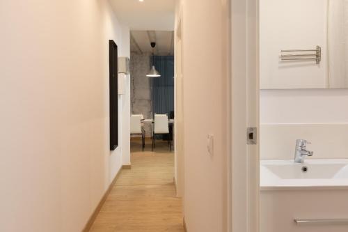 pasillo con lavabo y baño con mesa en Gothic - Ramblas Apartments, en Barcelona