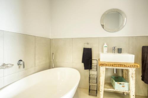 La salle de bains est pourvue d'une baignoire, d'un lavabo et d'un miroir. dans l'établissement Campismo Ninho 41, à Ponta Malangane