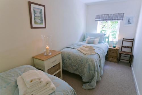 1 dormitorio con 2 camas y una vela sobre una mesa en Tyn Llan, en Bodorgan