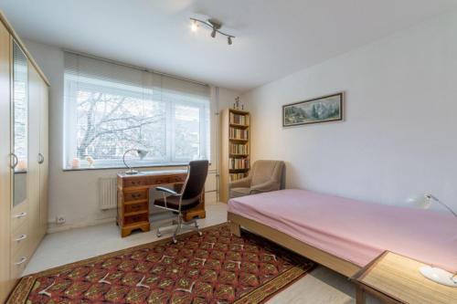 1 dormitorio con cama, escritorio y sofá cama en Private Rooms en Hannover