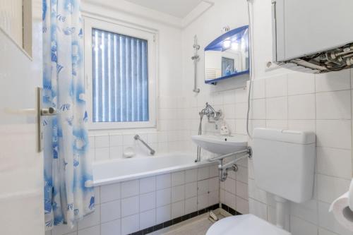 Baño blanco con lavabo y aseo en Private Rooms en Hannover