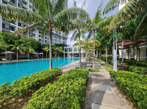 a swimming pool with palm trees next to a building at Tulip Homestay by AK Group in Cyberjaya