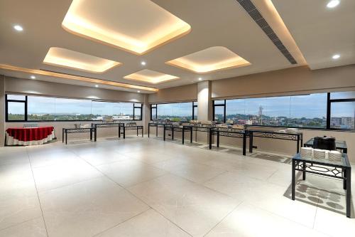 a large room with tables and windows in a building at Cygnett Inn Imperial Tezpur in Tezpur