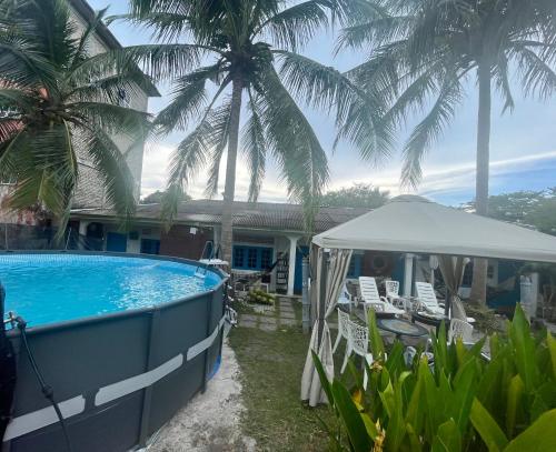 a house with a swimming pool and palm trees at Dar Yasmine Motel in Pantai Cenang