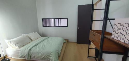 ein kleines Schlafzimmer mit einem Bett und einer Leiter in der Unterkunft Paddy Farm Cottage 鄉田民宿 (Full Aircon + Karaoke) in Alor Setar