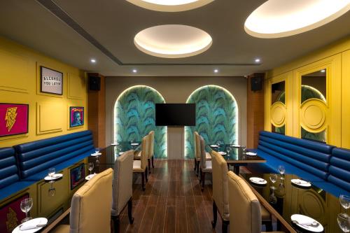 a restaurant with tables and chairs and a flat screen tv at Cygnett Inn Imperial Tezpur in Tezpur