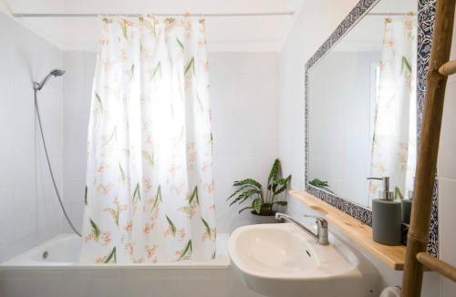 a bathroom with a sink and a shower curtain at Beach Front Villa in Shave Ẕiyyon