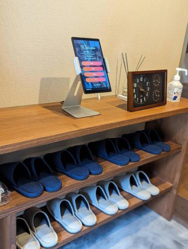 a shelf filled with lots of shoes and a clock at LOOP-shiso 宍粟市BBQとサウナでととのう天空回廊にたたずむ貸別荘 in Shiso