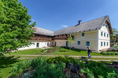 a person walking in front of a large house at Homutův statek in Kokořín