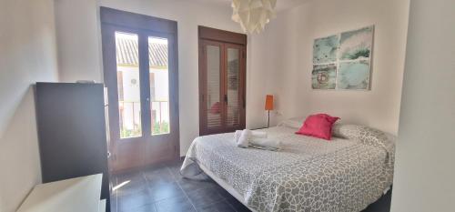 Un dormitorio con una cama con una almohada roja. en La casa de San fernando Mezquita, en Córdoba