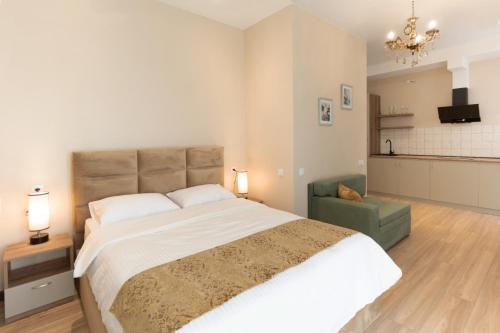 a bedroom with a large bed and a chandelier at Sky by the river in Tbilisi City