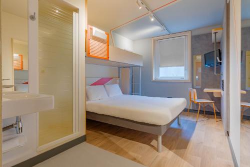 Cette petite chambre comprend un lit et un lavabo. dans l'établissement Ibis Budget Lyon Est Saint Quentin Fallavier, à Saint-Quentin-Fallavier