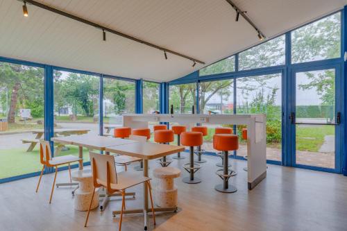 a conference room with tables and chairs and windows at Ibis Budget Lyon Est Saint Quentin Fallavier in Saint-Quentin-Fallavier