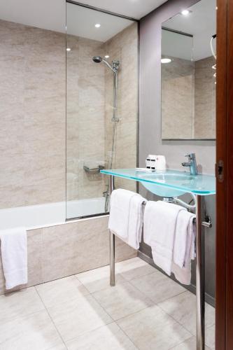 a bathroom with a shower and a sink and a tub at AS Porta de Barcelona in Castellbisbal