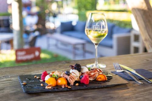 a plate of food and a glass of wine on a table at Hotel & Restaurant - Auberge De Hilver in Diessen
