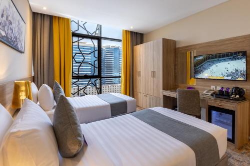 a hotel room with two beds and a television at Anan Hotel By Snood in Mecca