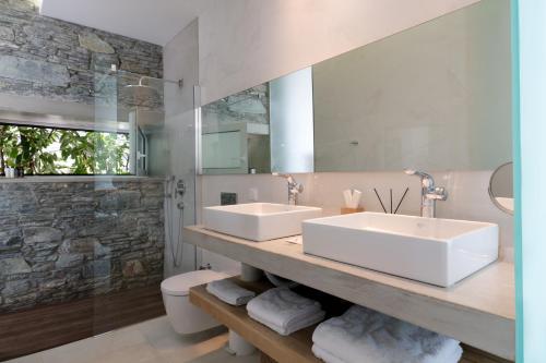 a bathroom with two sinks and a large mirror at A - Luxury Villas in Plomarion