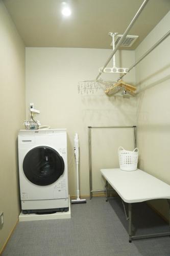 a laundry room with a washing machine and a bench at LOOP-shiso 宍粟市BBQとサウナでととのう天空回廊にたたずむ貸別荘 in Shiso