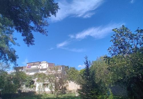 a building on the side of a hill with trees at Apartman Maida in Blagaj