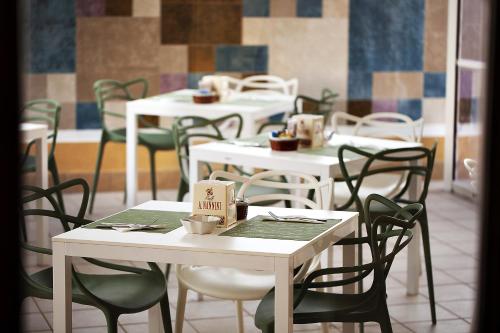 a dining room with white tables and chairs at FAVIGNANA HOTEL Concept Holiday in Favignana