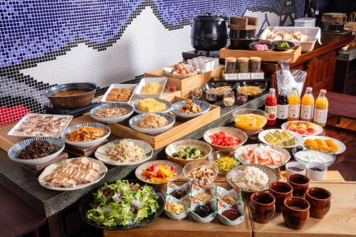 a buffet with many bowls of food on a table at Matsumoto Hotel Kagetsu in Matsumoto