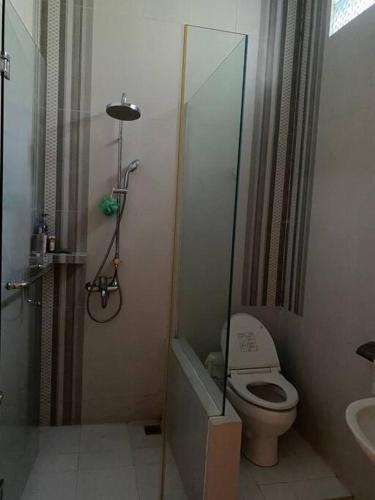 a bathroom with a shower and a toilet and a sink at Aldeoz Ndalem Marwatan Surakarta in Bonorejo