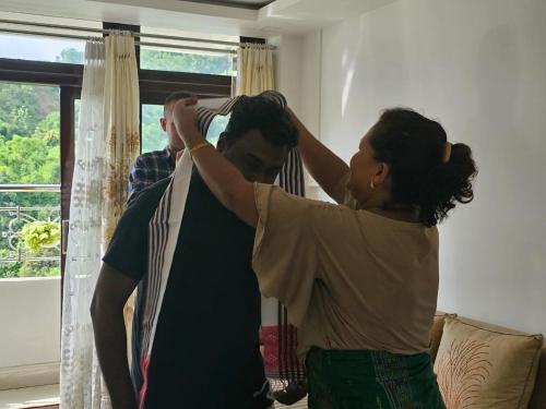 a woman standing next to a man tying his hair at Alub Naam Homestay in Itānagar