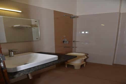 y baño con lavabo, aseo y espejo. en Hotel Adithya View en Dharmastala