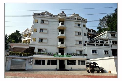 un vehículo estacionado frente a un gran edificio en Hotel Adithya View en Dharmastala