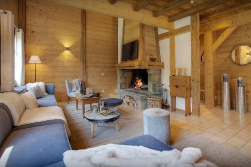 uma sala de estar com um sofá e uma lareira em Chalet Hollygotty - OVO Network em La Clusaz